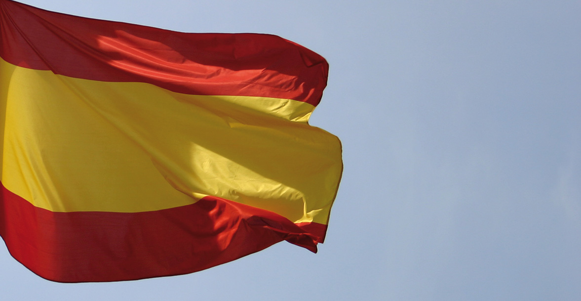 Wehende spanische Nationalflagge in rot-gelb-rot vor bewölktem Himmel