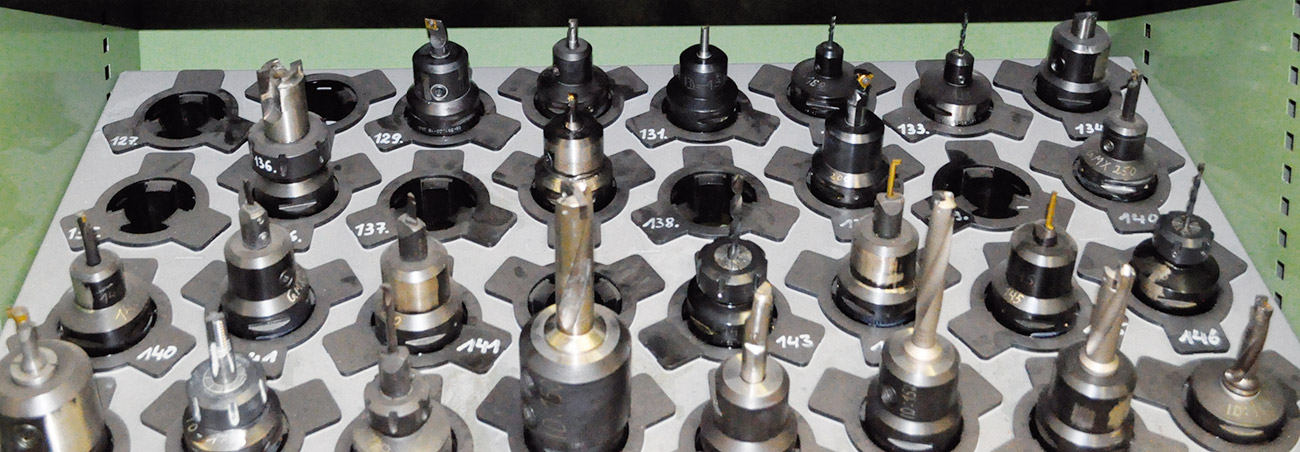 Overhead view of organized industrial tool holders with numbered machining tools and cutting bits arranged in a systematic grid pattern.